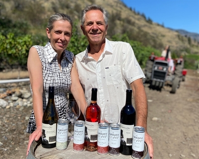 Castoro de Oro Proprietors in vineyard with wine